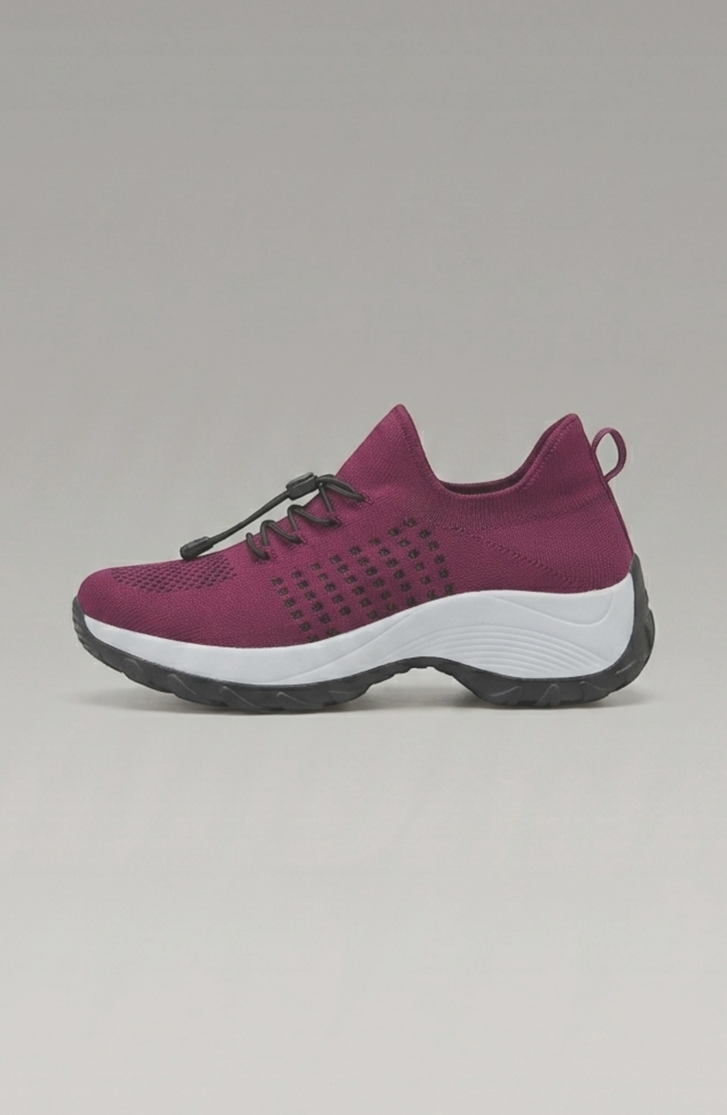 LORVENE Calm Glow sneakers shown on a model's feet, featuring a sleek design and light-colored athletic footwear.