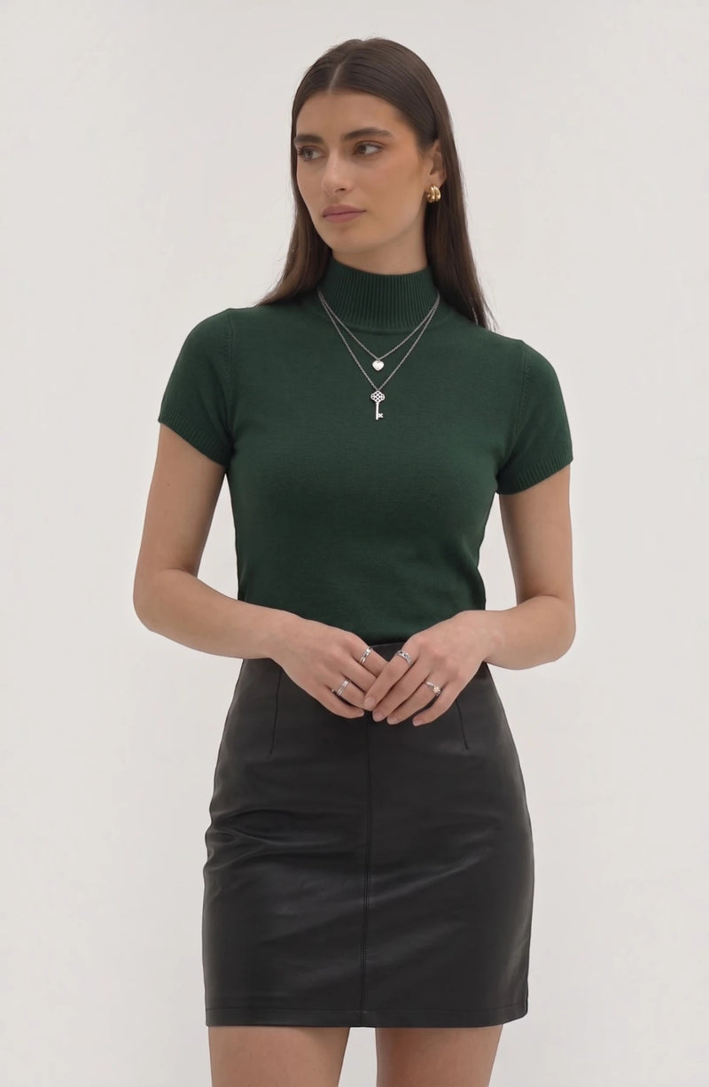 LORVENE Pure Poly Blend High Neck top displayed on a hanger, showcasing its smooth fabric and high neckline style.