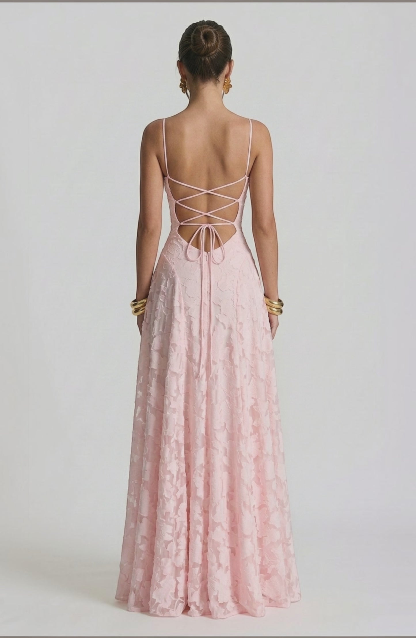 Model wearing a sexy, flowy bridal dress in a soft color by LORVENES, featuring elegant fabric and a graceful silhouette.