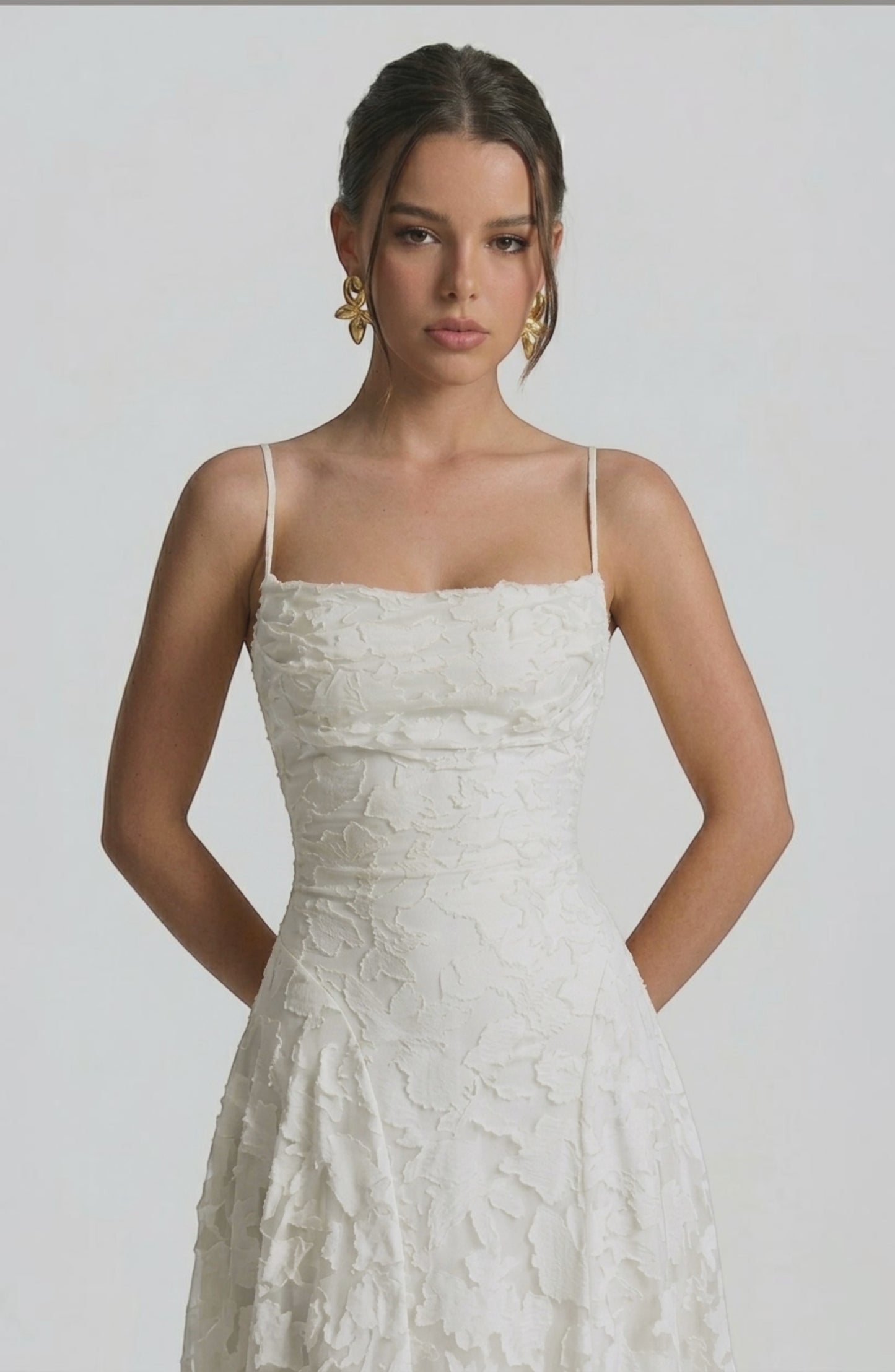 Model wearing a flowy bridal dress by LORVENES, featuring a romantic, elegant silhouette with delicate fabric and intricate details.
