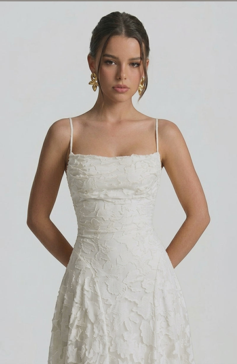 Model wearing a flowy bridal dress by LORVENES, featuring a romantic, elegant silhouette with delicate fabric and intricate details.