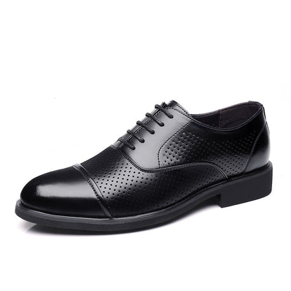 Black leather dress shoe with a close-up of the sole on a white background