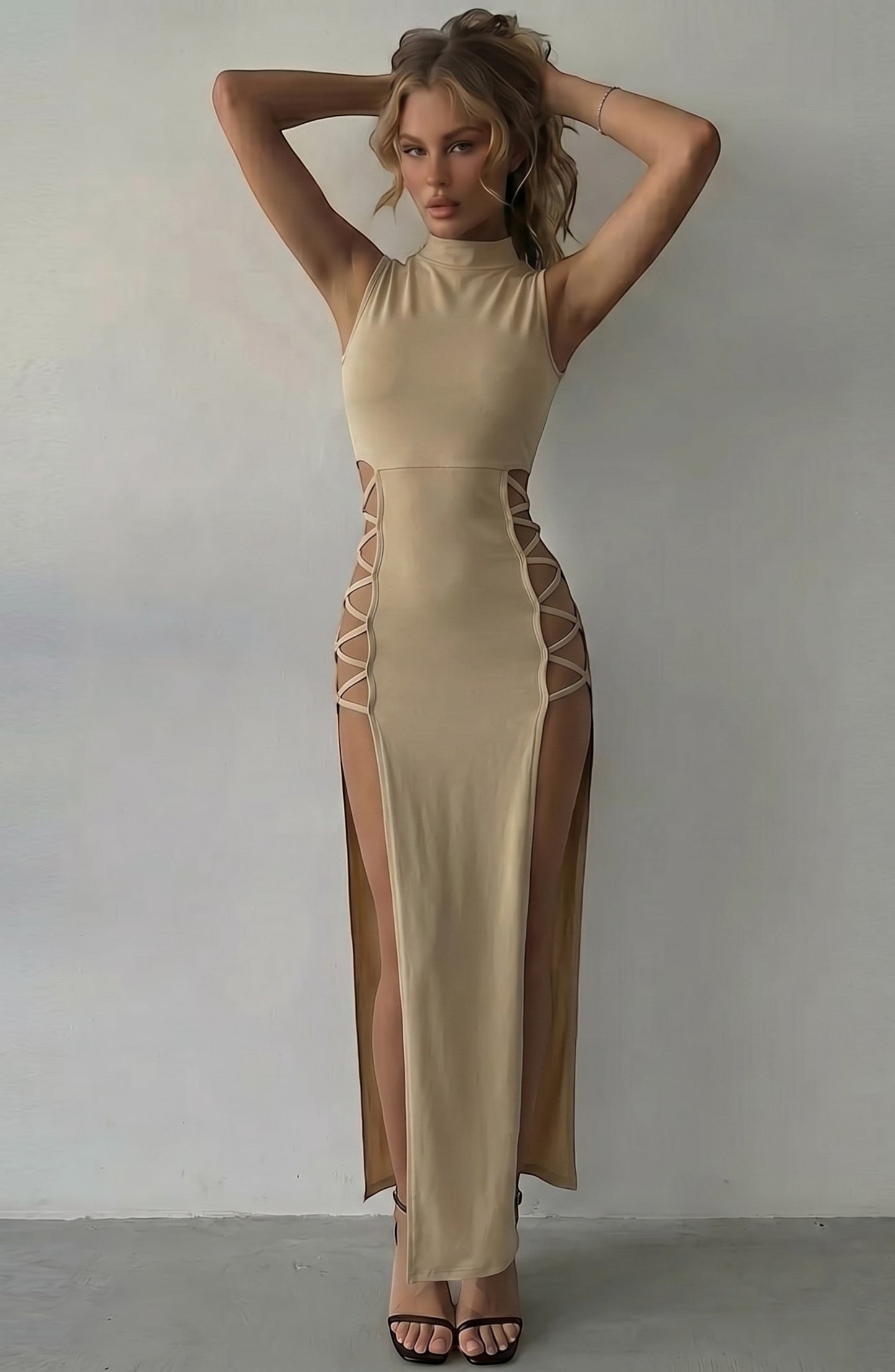 LORVENE beige sleeveless mock neck maxi dress with daring side cutouts and high slits, designed for evening wear.