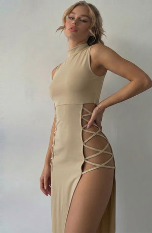 LORVENE beige sleeveless mock neck midi dress with lace-up side cutouts and high slit. Model is wearing a size small.
