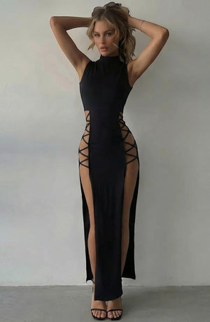 LORVENE black sleeveless mock neck maxi dress with lace-up side cutouts and high slits. Model is wearing strappy heels.