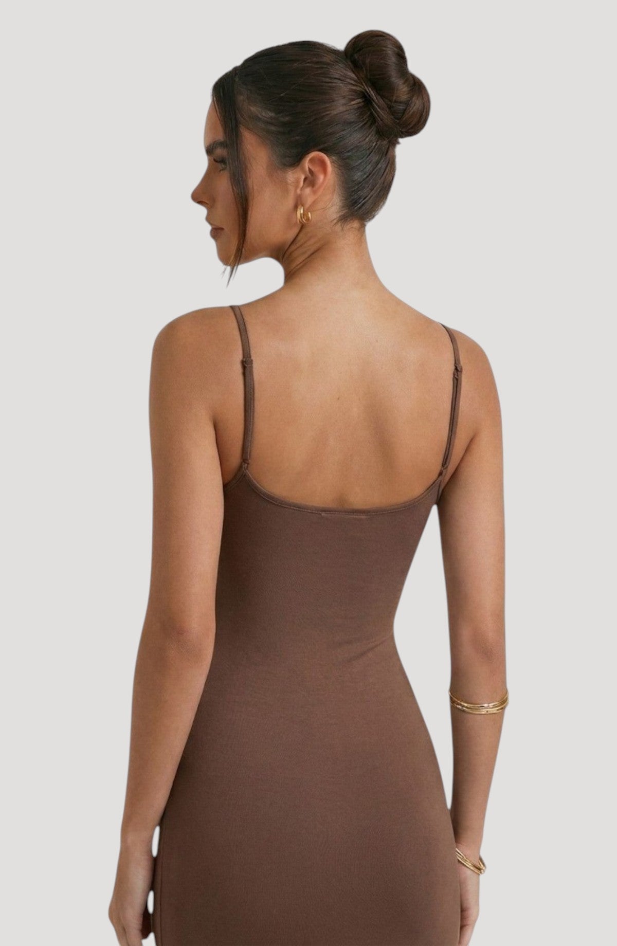 LORVENE brown slip dress with adjustable spaghetti straps and a flattering midi length. Smooth fabric with a subtle sheen.